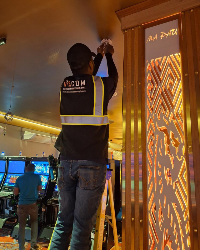Viscom Security Solutions technician installing a ceiling camera inside a commercial venue